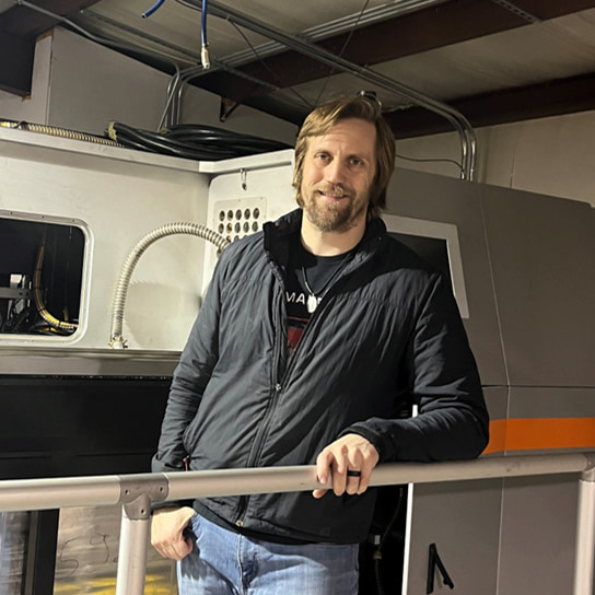 Dr. John Middendorf, Co-founder of Laser Fusion Solutions, in front of an Open Additive LPBF printer